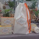 Sac en tissu fermé par un ruban orange de la savonnerie du loup qui chante